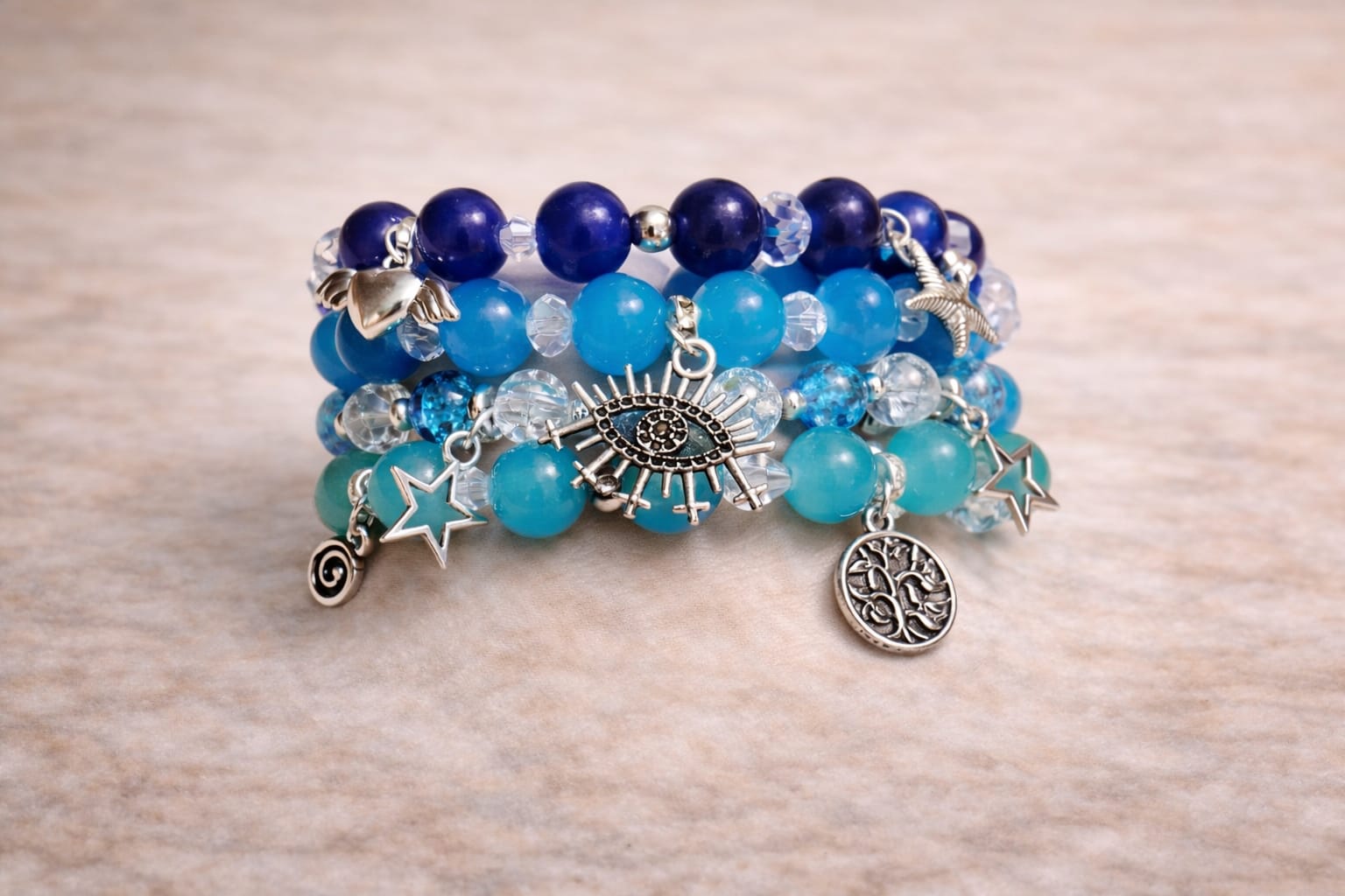 Close-up of navy and crystal bead bracelets with starfish, evil eye, and star charms