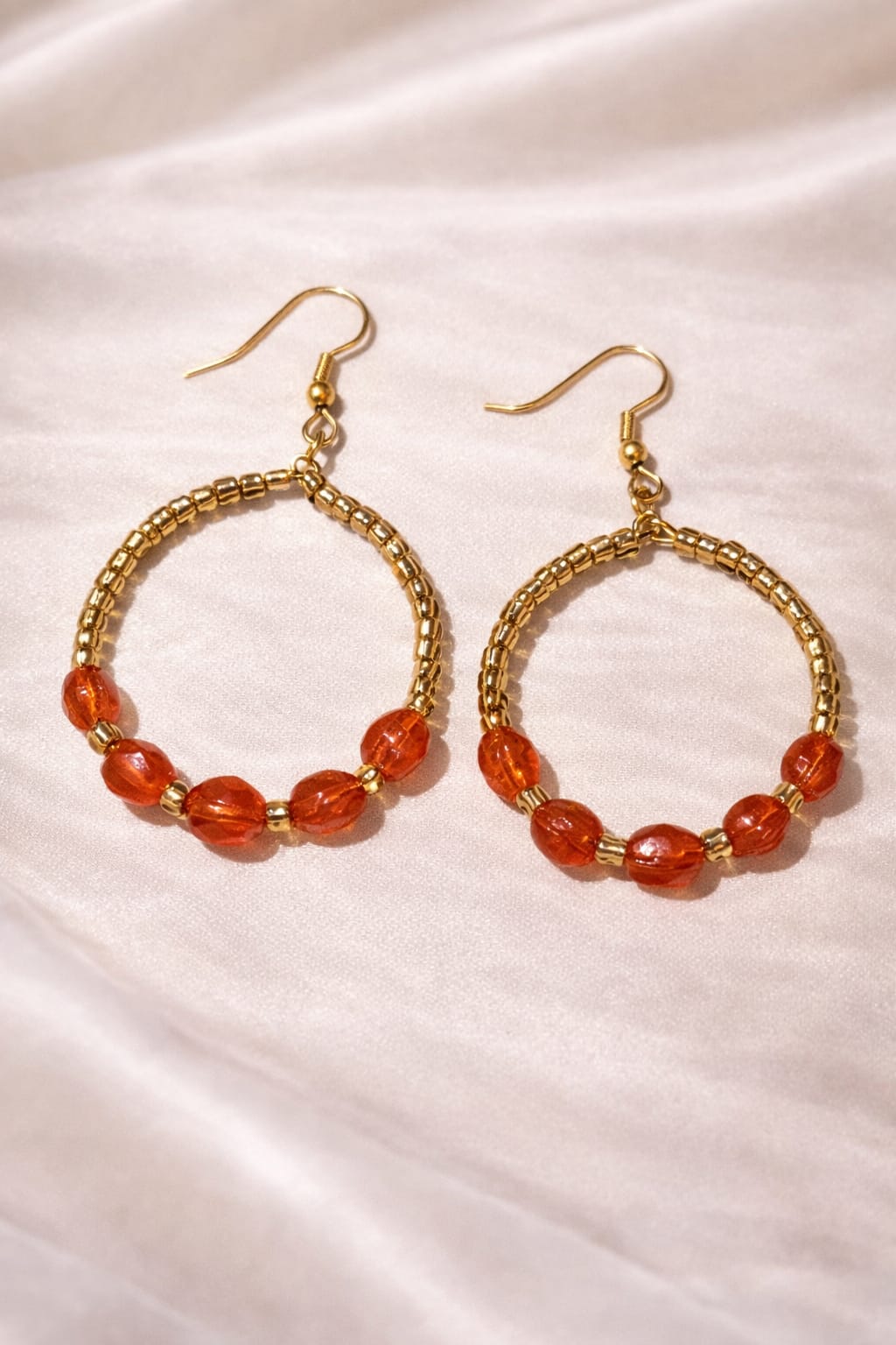 Orange and gold beaded hoop earrings with gold fish hook wires