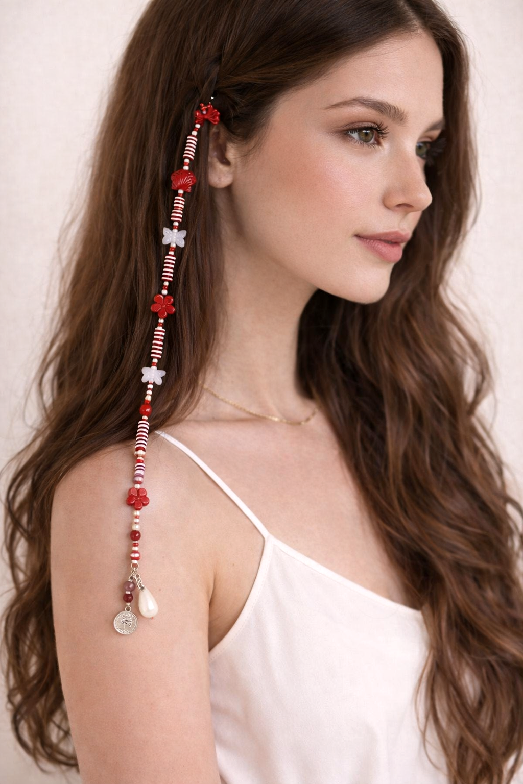 Close-up of romantic red beaded hair clip with floral accents and dangling charms